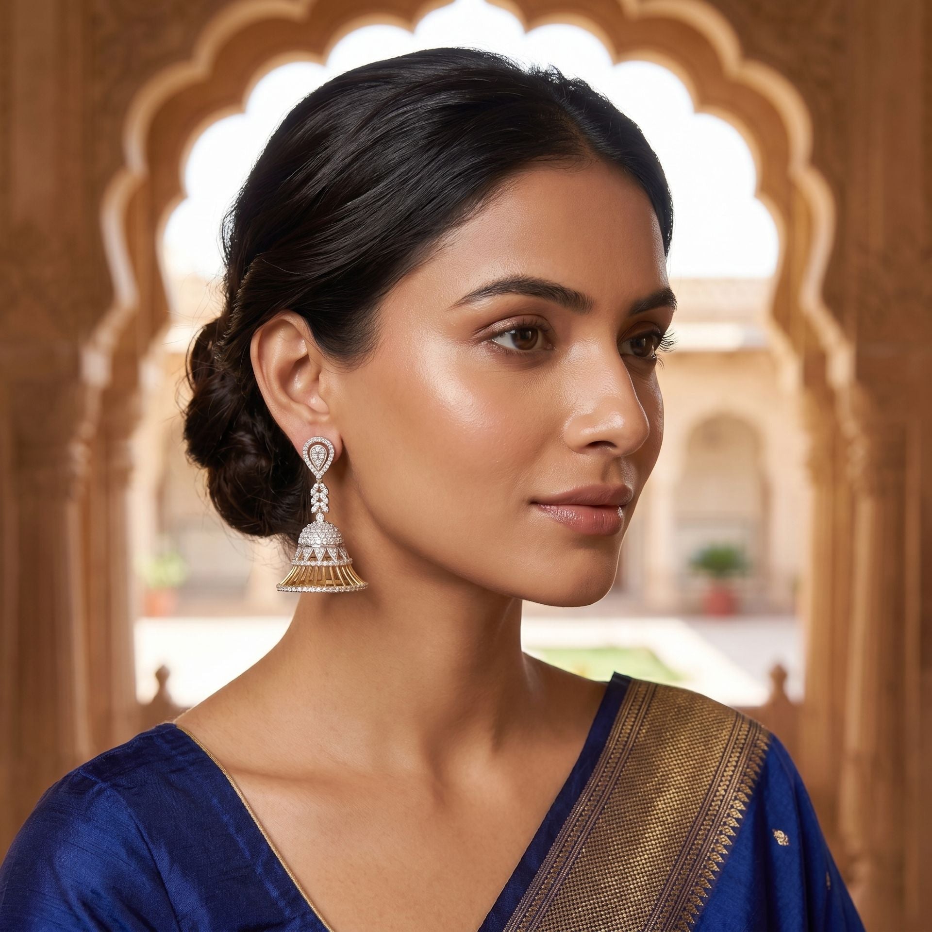 Woman wearing sparkling geometric lab-grown diamond stud earrings in a close-up portrait.
