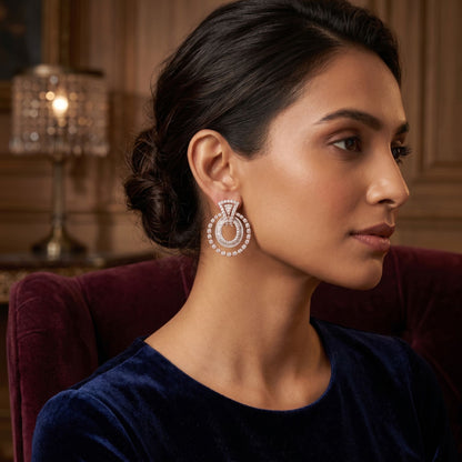 Woman wearing elegant halo drop earrings featuring sparkling lab-grown diamonds in a sophisticated indoor portrait.