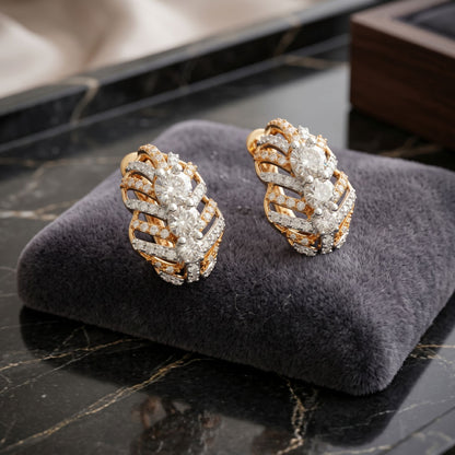 Geometric gold stud earrings featuring sparkling lab-grown diamonds displayed on a dark luxury background.