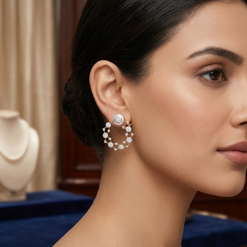 Close-up of a woman wearing diamond hoop earrings with a blurred jewelry store background.