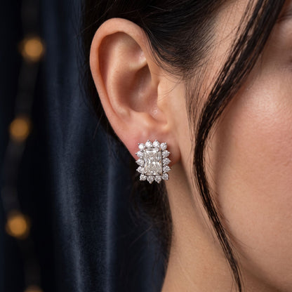 Close-up of an ear wearing a diamond earring with a blurred background