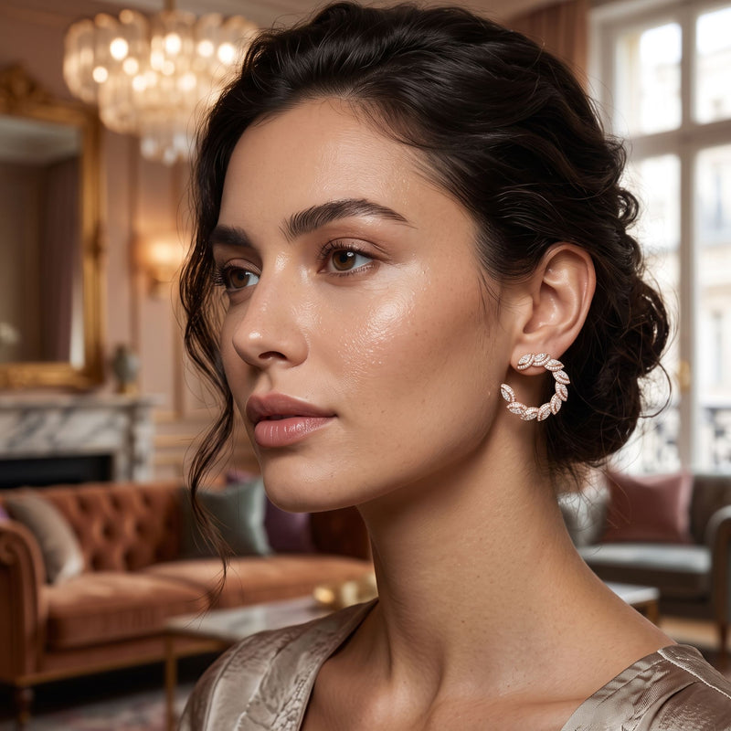 Woman wearing hoop earrings in an elegant room with a chandelier and sofa.