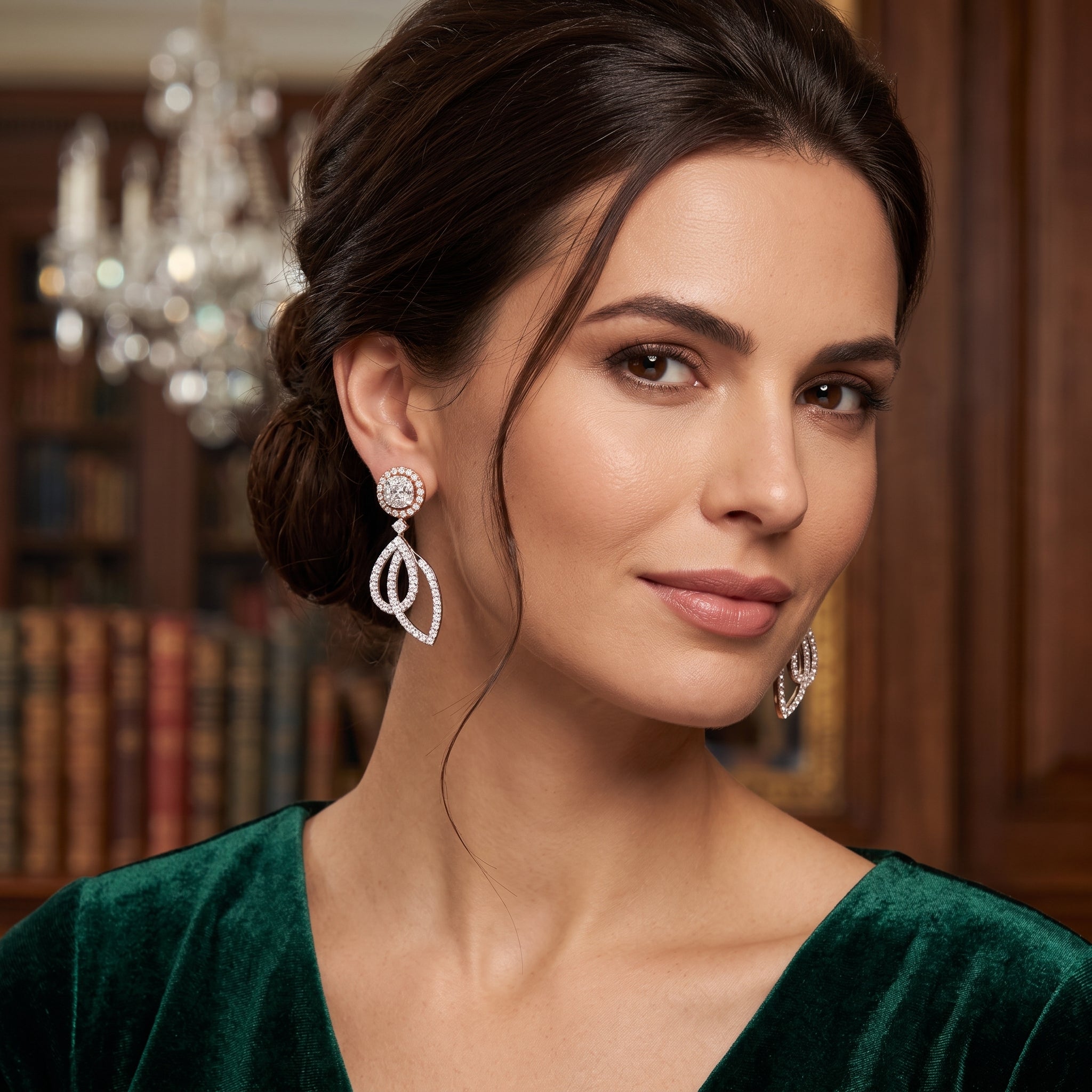 Woman wearing elegant earrings in a room with a chandelier and bookshelf.