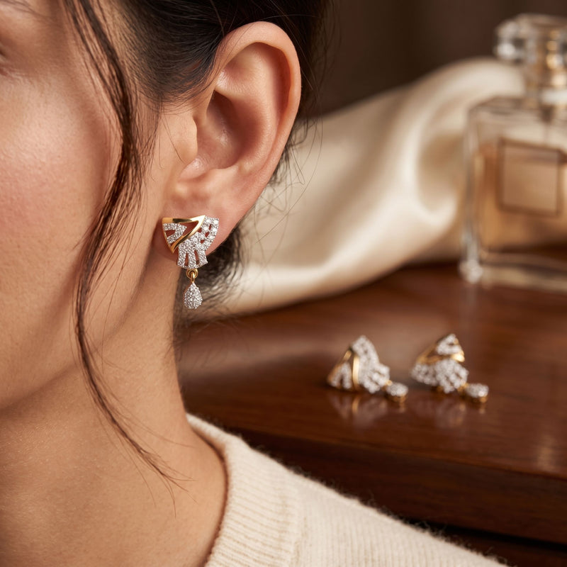 Close-up of a woman wearing diamond earrings with a perfume bottle in the background.