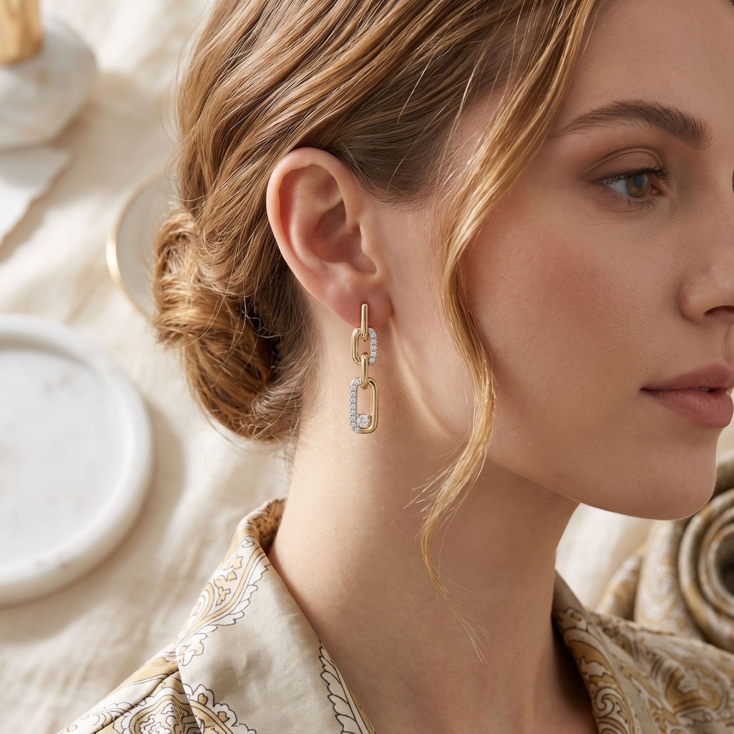 Close-up of a woman wearing gold earrings with a neutral background