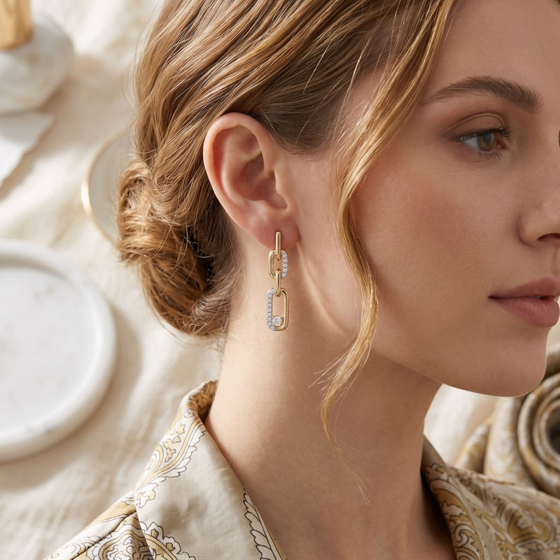Close-up of a woman wearing gold earrings with a neutral background