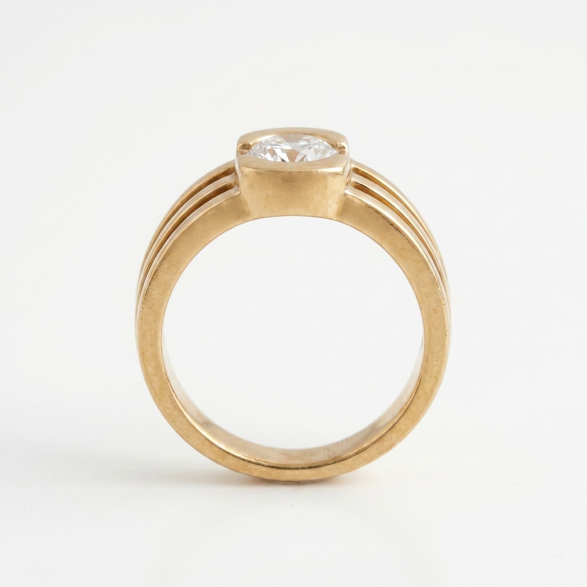 Gold ring with a diamond on a white background